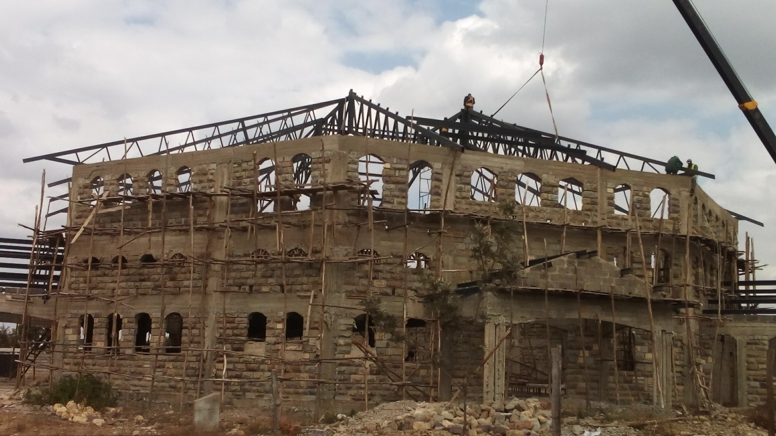 Steel roof truss erection on a stone masonry building